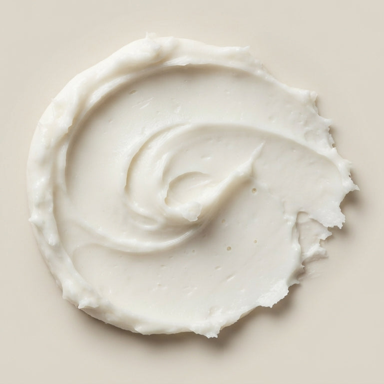 Close-up of whipped magnesium lotion texture, swirled onto a neutral surface