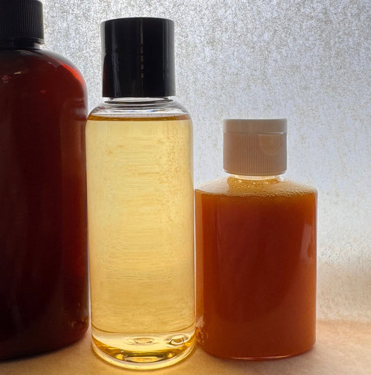 Three bottles of different sizes on a reflective surface