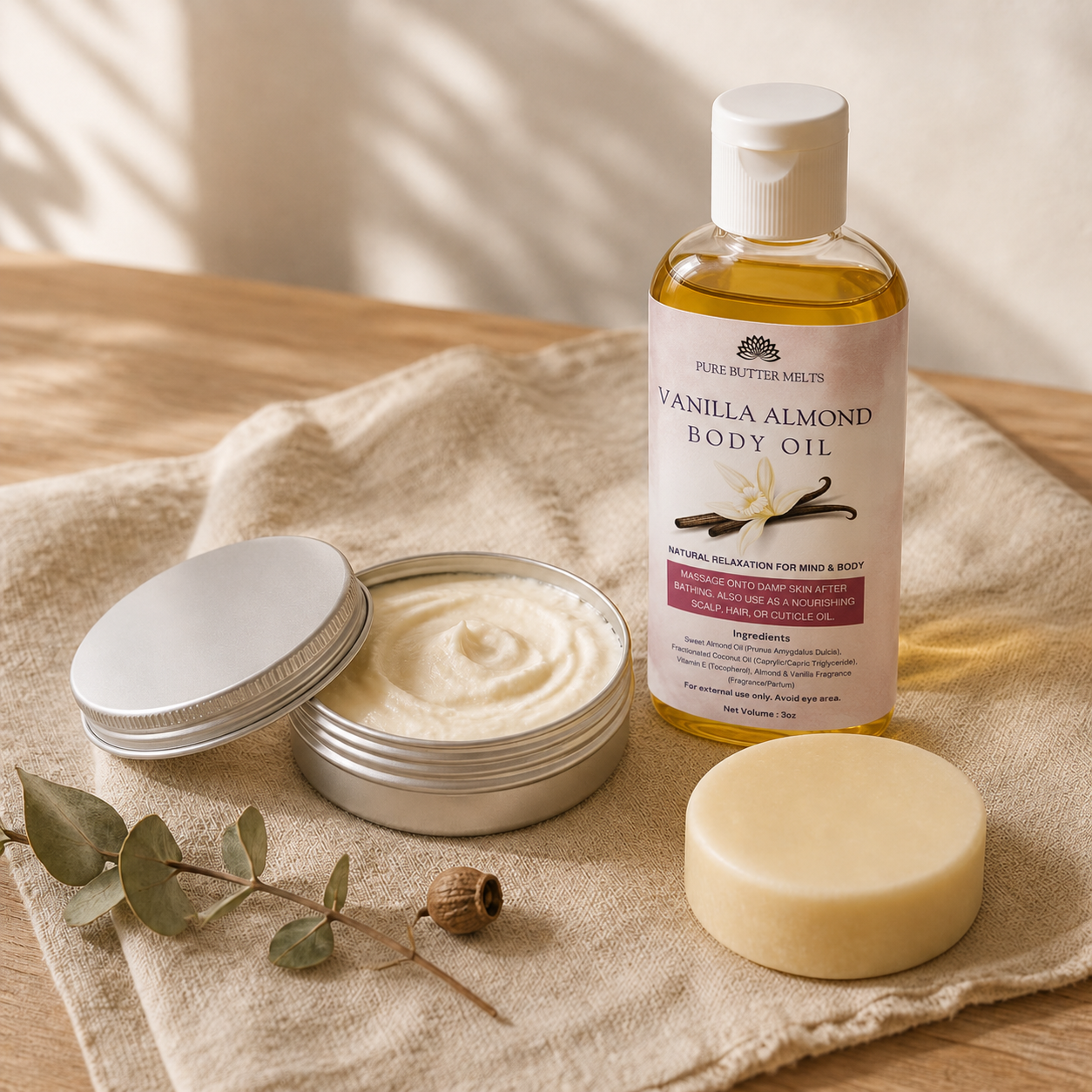 The Autumn Ritual bundle flat-lay — round Goat's Milk Soap bar, whipped Body Butter tin, and Body Oil bottle on natural linen — PureButterMelts