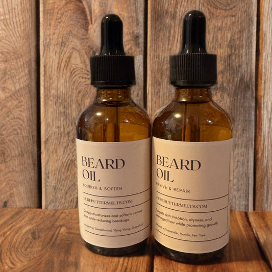 Two PureButterMelts Beard Oil bottles — Nourish & Soften and Revive & Repair — amber glass with dropper on rustic wood