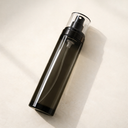 hydrosol face mist bottle on warm cream stone background with soft natural light and shadow.