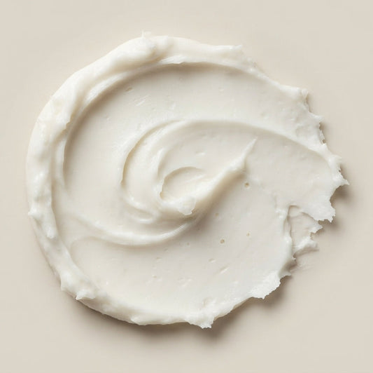 Close-up of whipped magnesium lotion texture, swirled onto a neutral surface