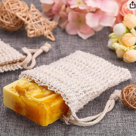 Sisal soap pouch holding a golden honey-toned soap bar, styled with dried flowers — PureButterMelts