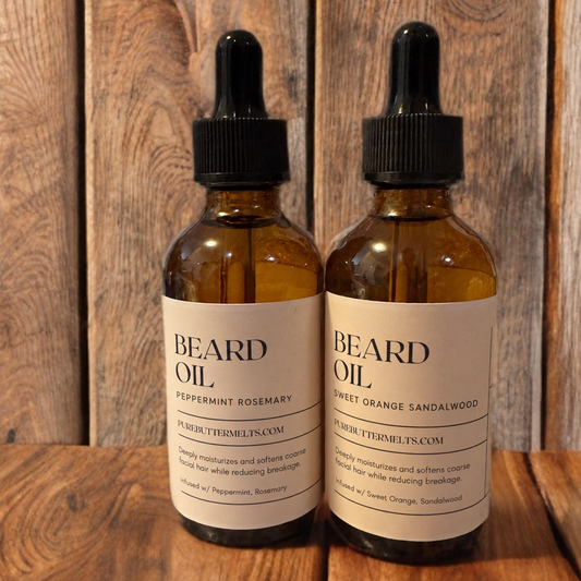 Two amber glass dropper bottles of Beard Oil, Sweet Orange Sandalwood and Peppermint Rosemary, on rustic wood — PureButterMelts